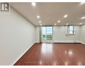 A room with a wooden floor and a sliding glass door leading to a balcony.