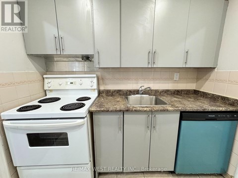 A white stove and oven in a kitchen with white cabinets and a granite counter.