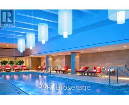 A pool area with red chairs and a blue light.