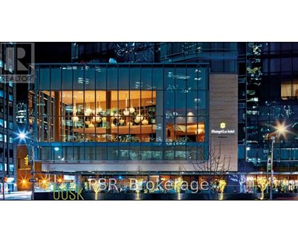A modern building with a glass facade and the words "Shangri-La Hotel" on it.