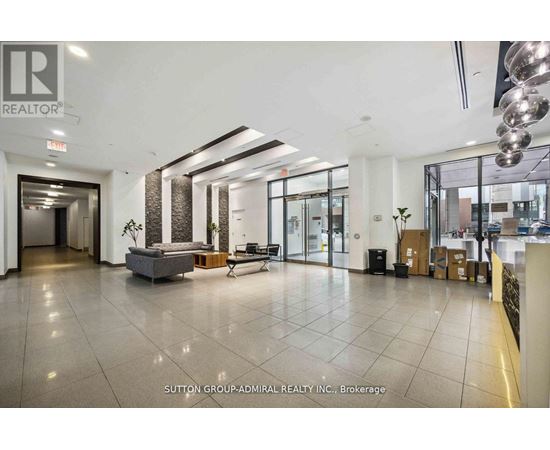 A spacious office lobby with a reception desk and a seating area.