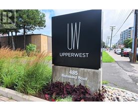 A sign for Upperwest stands in front of a building.