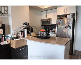 A kitchen with a refrigerator covered in magnets and notes.