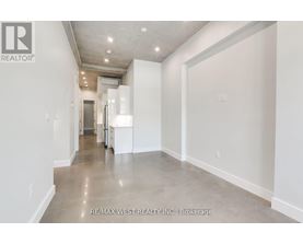A long hallway with white walls and a tiled floor.
