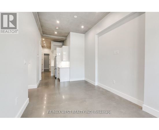 A long hallway with white walls and a tiled floor.