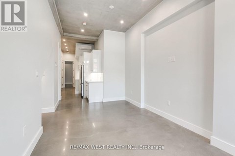 A long hallway with white walls and a tiled floor.