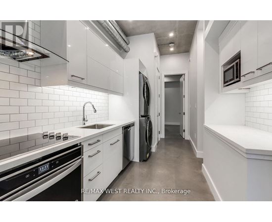 A modern kitchen with white cabinets and stainless steel appliances.