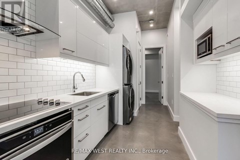A modern kitchen with white cabinets and stainless steel appliances.