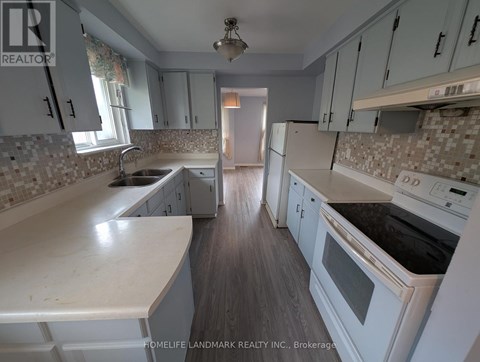 A kitchen with white cabinets and a tiled backsplash.