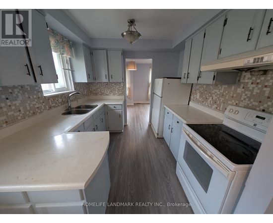 A kitchen with white cabinets and a tiled backsplash.