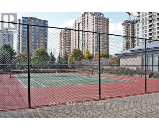 A tennis court is enclosed by a black fence.