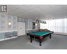 A pool table in a room with a light blue wallpaper.