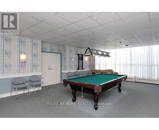 A pool table in a room with a light blue wallpaper.