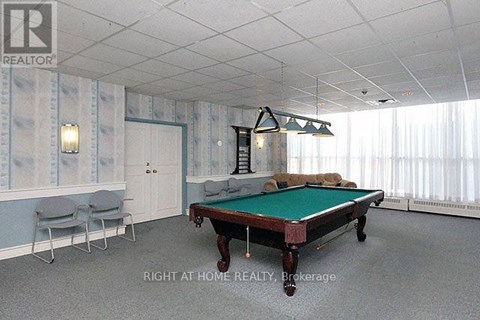 A pool table in a room with a light blue wallpaper.
