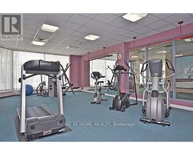 A gym with a treadmill, elliptical machines and other exercise equipment.
