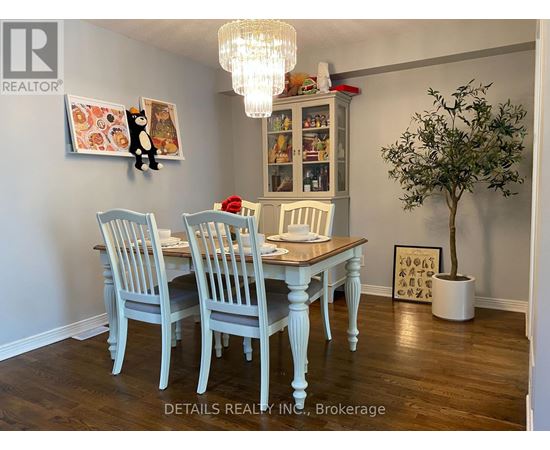 A dining room with a wooden table and chairs.