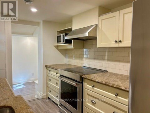 A kitchen with a stove top oven and a microwave above it.