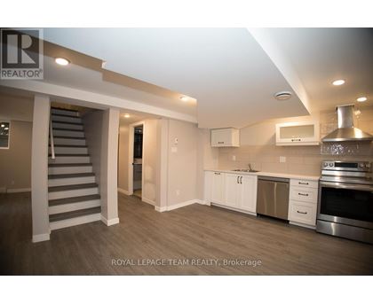 A spacious kitchen with stainless steel appliances and white cabinetry.