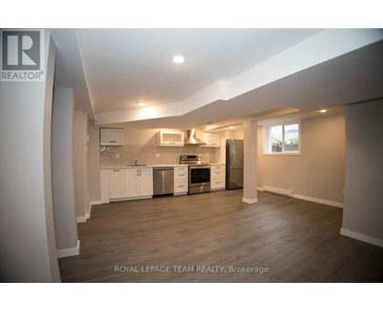 A spacious kitchen with white cabinets and stainless steel appliances.