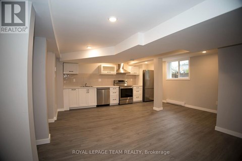 A spacious kitchen with white cabinets and stainless steel appliances.