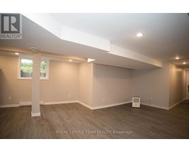 A spacious room with a large window and a white pillar in the middle.