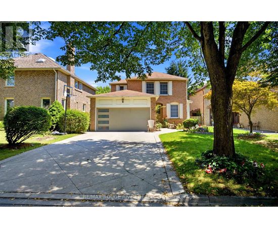 A house with a driveway and a tree in front.