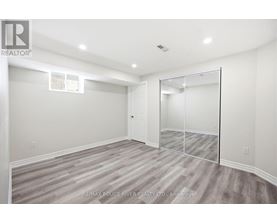 A spacious room with a grey carpet and a white door.