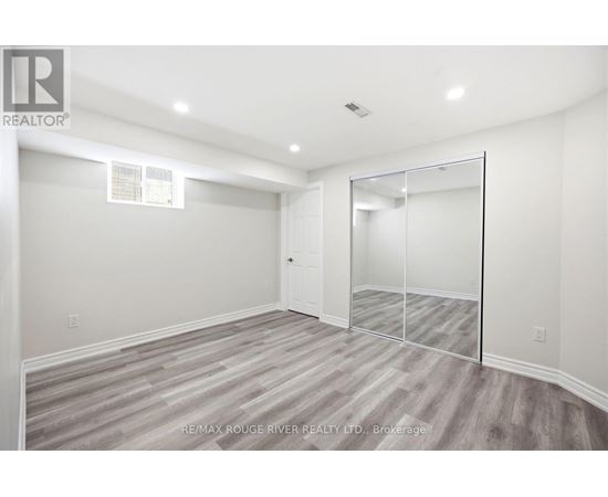 A spacious room with a grey carpet and a white door.