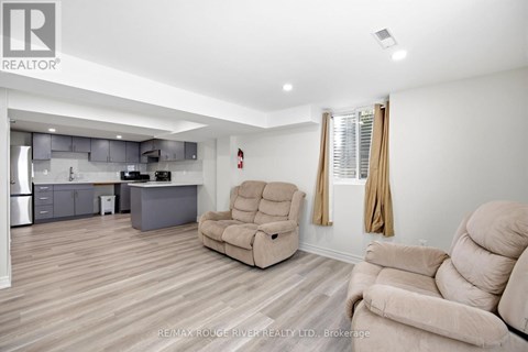 A living room with a beige couch and a matching chair.