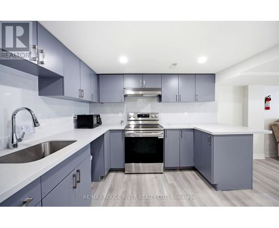 A modern kitchen with a stainless steel oven and grey cabinets.