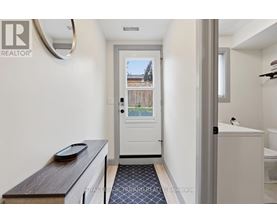 A white bathroom with a door leading to a balcony.