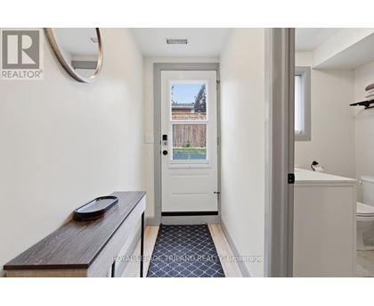 A white bathroom with a door leading to a balcony.