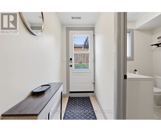 A white bathroom with a door leading to a balcony.