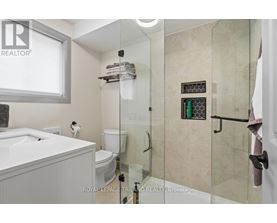 A white bathroom with a glass shower door.