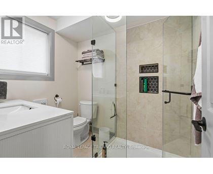 A white bathroom with a glass shower door.