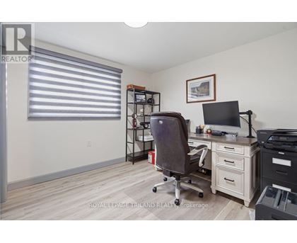 A room with a desk, chair, and printer.