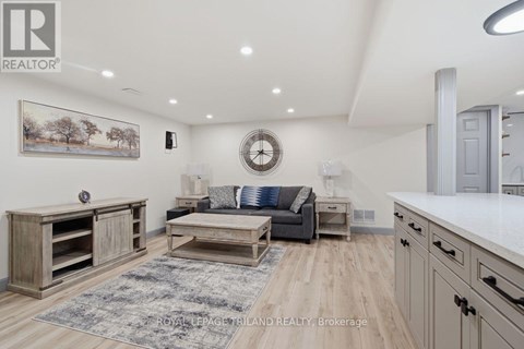A well-lit living room with a grey sofa and wooden furniture.
