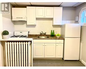 A kitchen with white cabinets and appliances.