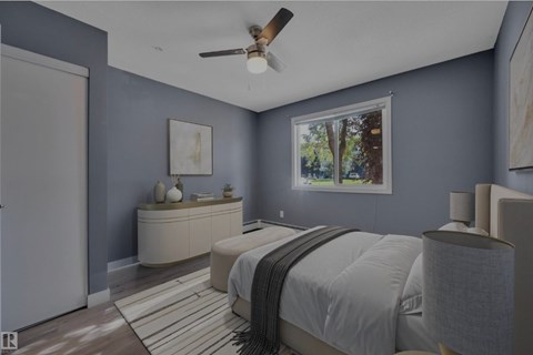 A bedroom with a bed, dresser, and ceiling fan.
