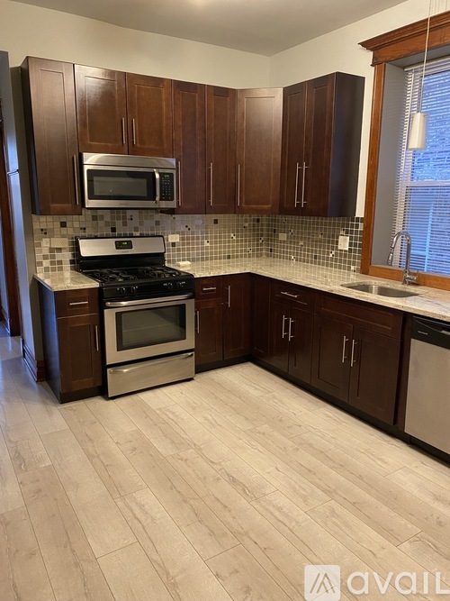 A kitchen with wooden cabinets and a tiled backsplash.