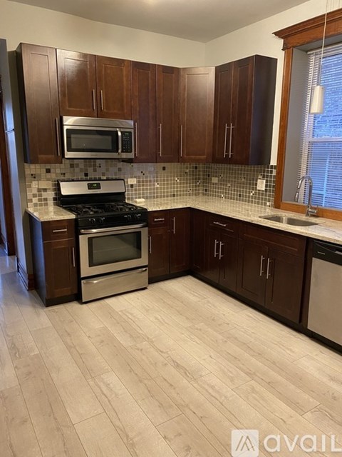 A kitchen with wooden cabinets and a tiled backsplash.