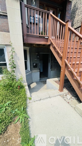 A wooden staircase leads to a doorway in a building.