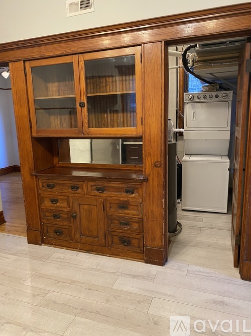 A kitchen with a wooden cabinet and a white fridge.