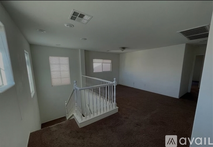 A room with a staircase and two windows.