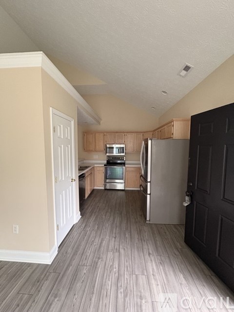 A kitchen with a refrigerator, oven, and sink.