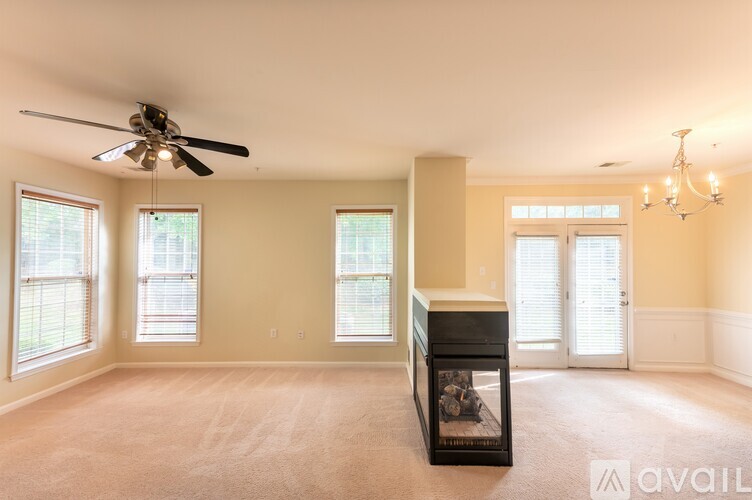A living room with a fireplace and a ceiling fan.