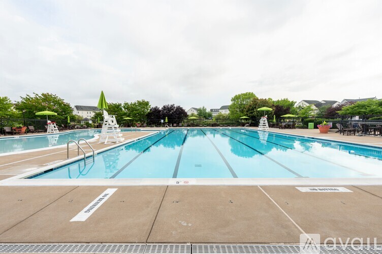 A large outdoor swimming pool with lanes marked on the bottom.