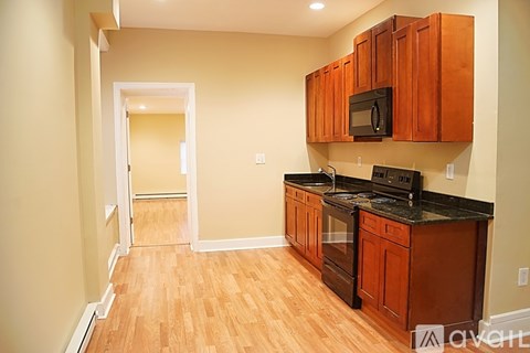 A kitchen with wooden cabinets and black countertops.