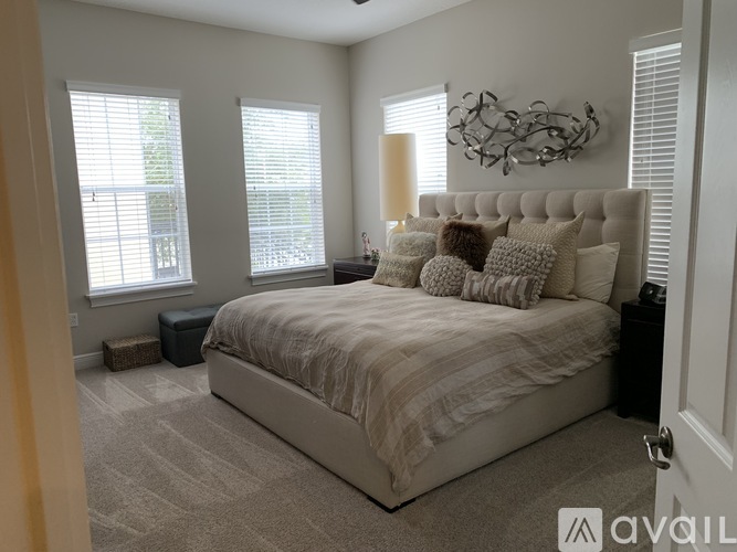 A bedroom with a large bed and a chandelier.