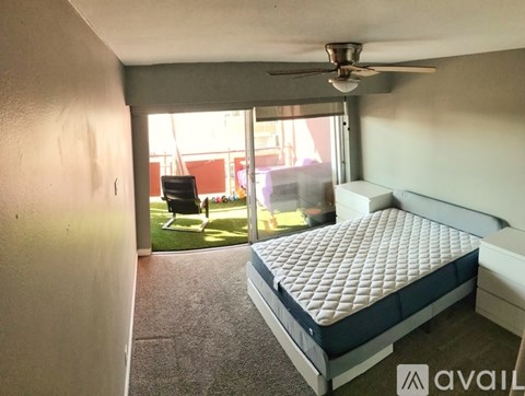 A bedroom with a large bed and a ceiling fan.